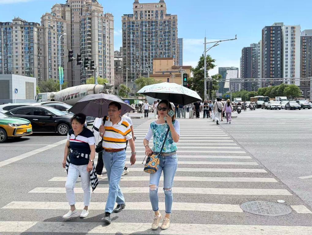 5月10日,市民在北京市朝阳区街头打伞防晒。新华社记者 陈钟昊 摄
